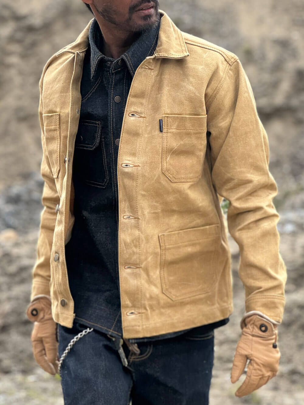 Close up view of custom-made sand canvas chore jacket with metal buttons.