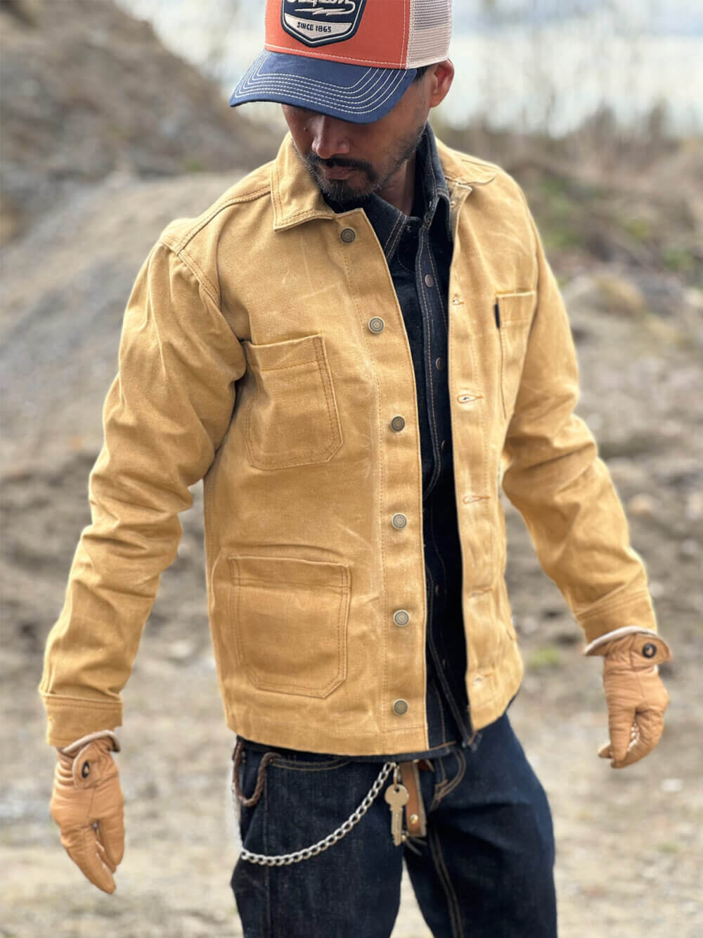 Close up view side of custom-made sand canvas chore jacket with metal buttons.